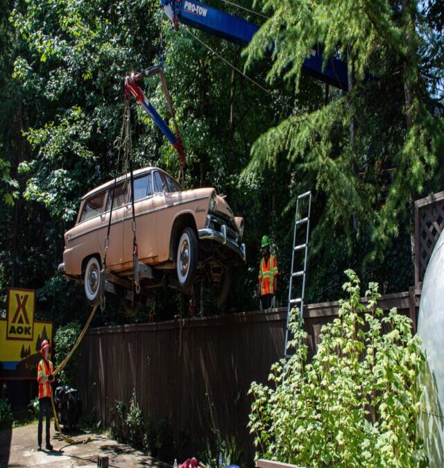 Classic Car Lifted Over a Fence